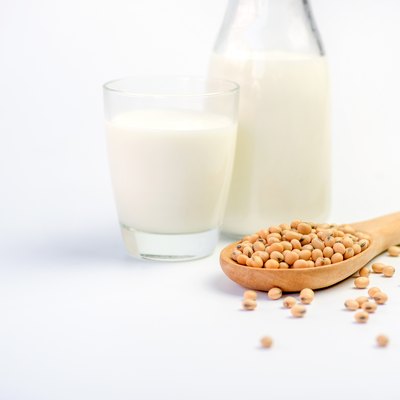 Milk with soy beans on white background