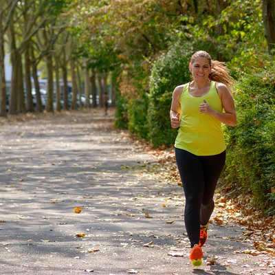 Determined middle-aged woman jogging in the park