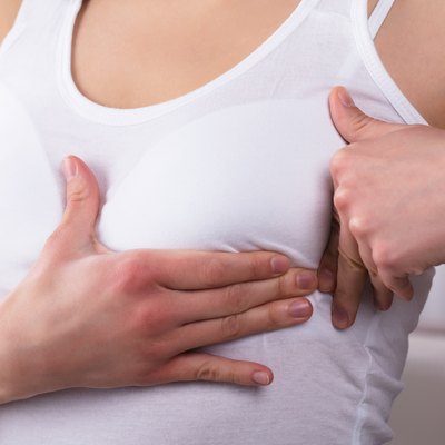 A woman feeling her swollen breast
