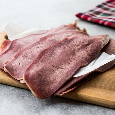 Sliced Beef Tongue Slices on Wooden Board.