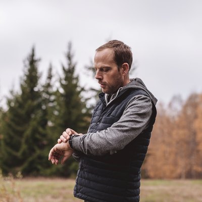 Man with fitness tracker walking outdoors in nature