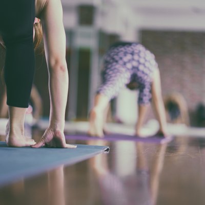 Group of young woman stretching and practicing during their yoga class