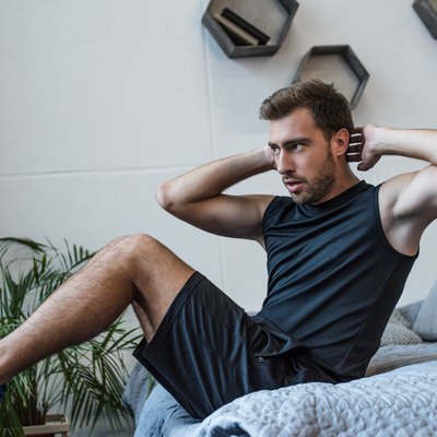 Man doing a morning HIIT workout in his bedroom