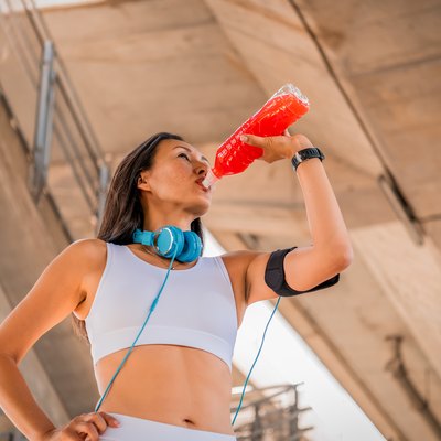 Beautiful Asian girl drinking water from a bottle after jogging.