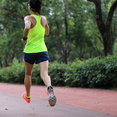 Fitness sporty woman jogger running at outdoors jogging track in park