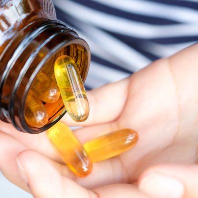 Woman's hand Holding fish oil in hand She is going to eat the supplement