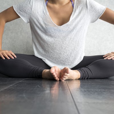 Young dancer pressing legs down into butterfly position