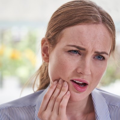 Woman in pain holding the right side of her jaw