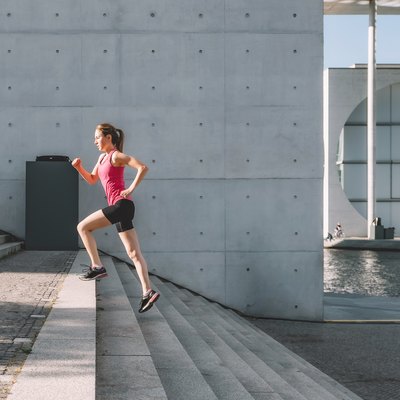 sports woman running up stairs outdoors