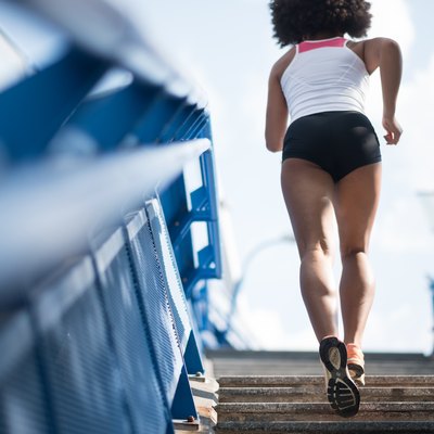 Sporty woman running upstairs - fitness concept