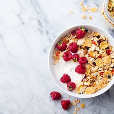 Healthy breakfast. Fresh granola, muesli, yogurt, berries on marble background. Top view. Copy space