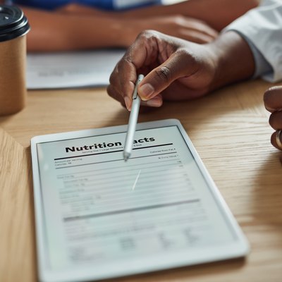 Dietitian's hand pointing to nutrition facts label on an iPad