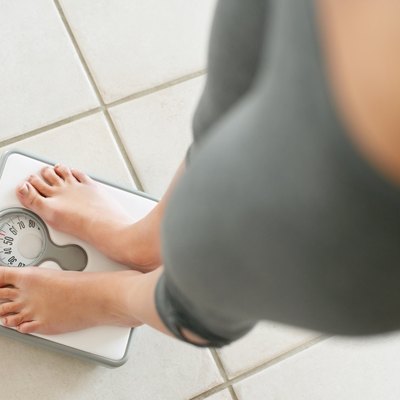 Low section of a girl weighing herself