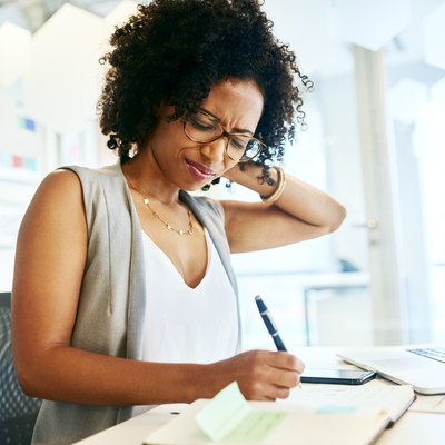 Woman with ear and neck pain working at a desk