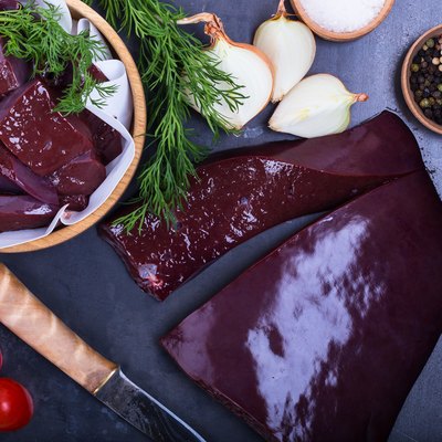 Raw beef liver over gray background viewed from above