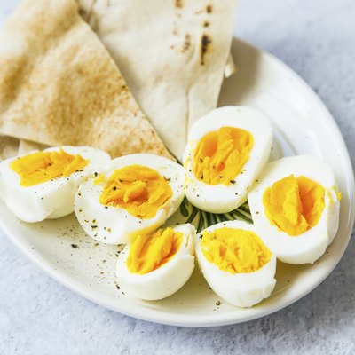 Boiled eggs cutted in halfs seasoned with pepper and salt with pita bread on a plate, healthy appetizers meal