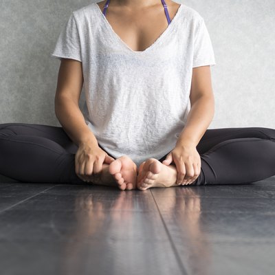 Female dancer sitting down in butterfly pose doing yoga