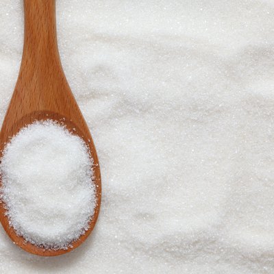 Wooden spoonful of white sugar just scooped up