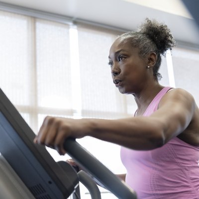 Mature woman exercising on elliptical machine
