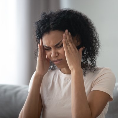 Woman touches temples, reduces sharp headache