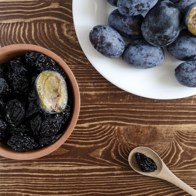 plum and dried plum on a wooden background top view prunes