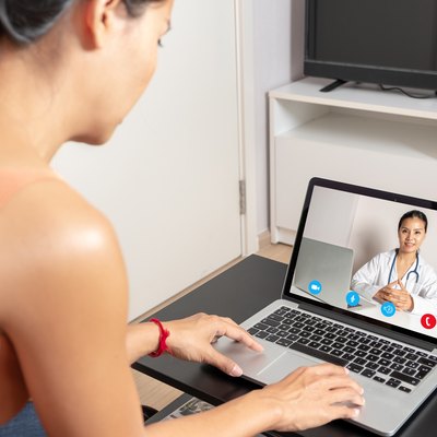 Woman using a laptop for a video call with a doctor