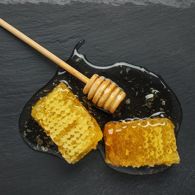 honeycomb and honey stick on a black