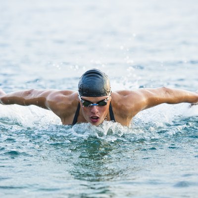 Female swimmer at butterfly stroke in the sea