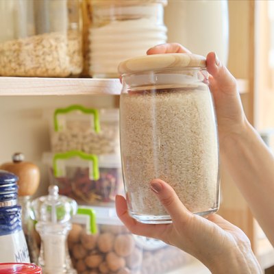 Food products in the kitchen. Woman taking jar of rice
