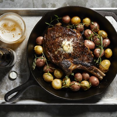 Skillet with large tomahawk steak & potatoes, overhead view