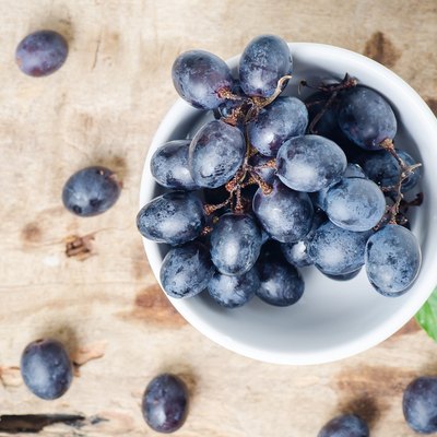 Black seedless grapes in a bowl on wooden