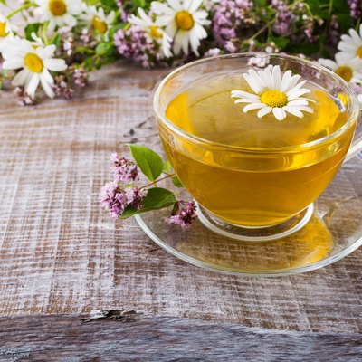 Cup of green herbal camomile tea and herbs