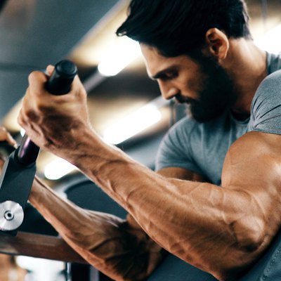 Young handsome man doing exercises in gym