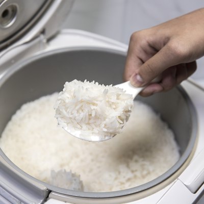 Scoop of cooked rice in an electric cooker.