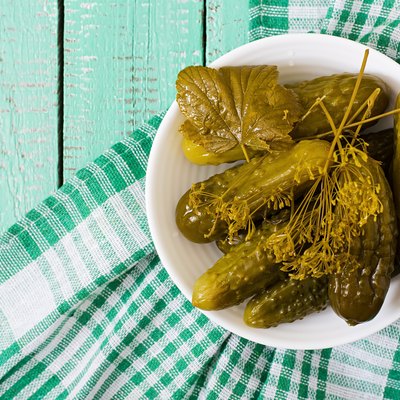 Pickled cucumbers on wooden background.