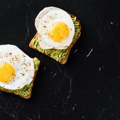 Fried egg and mashed avocado on toasted bread in daily cholesterol intake