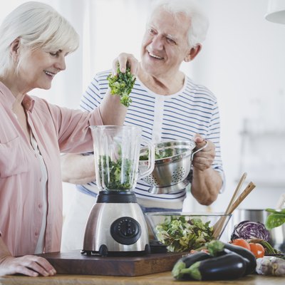 Happy older couple on a diabetes diet making healthy smoothies at home