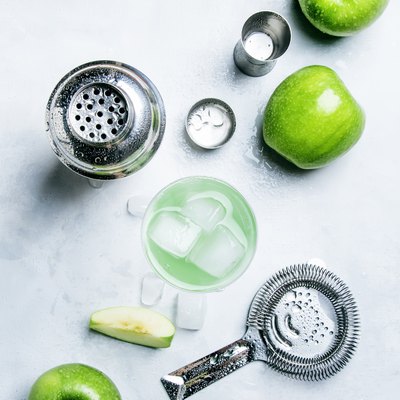 Summer alcoholic cocktail with green apple, vermouth and ice