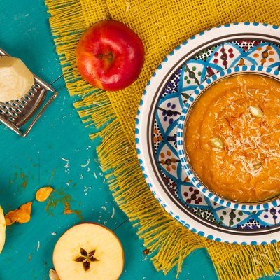 Homemade pumpkin cream soup with parmesan cheese and peeled pumpkin seeds.