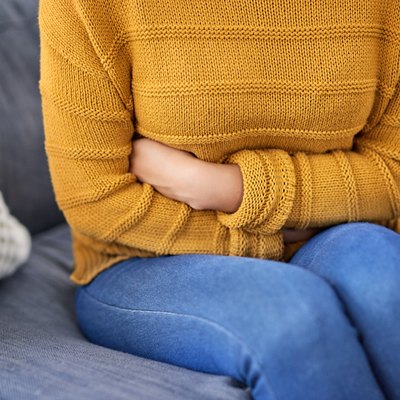 A woman with IBS symptoms holding her stomach