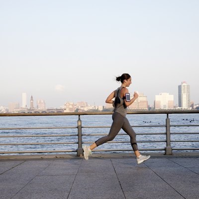 Young woman running along Hudson River