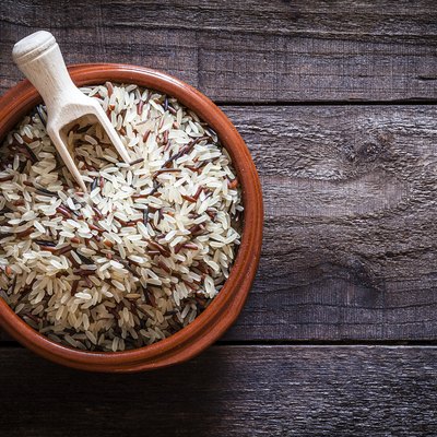 Brown bowl filled with mixed rice shot from above on rustic wooden table