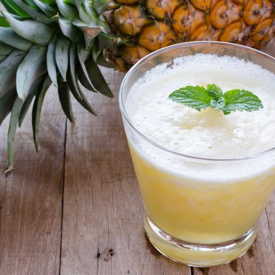 Glass of pineapple juice on wooden table