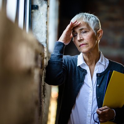 Senior businesswoman experiencing a headache from low sodium levels