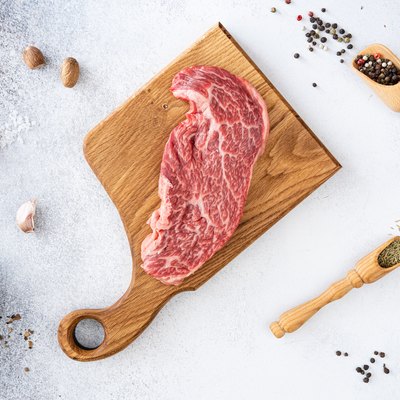 Fresh raw beef meat Denver Steak with peppercorns, seasonings and spices, ready to grill. Top view