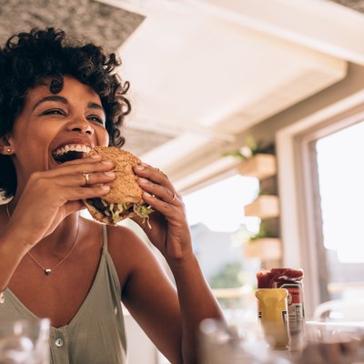 Woman enjoying eating a burger at a restaurant