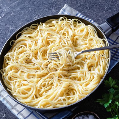 cacio e pepe, traditional Italian dish of pasta spaghetti mixed with grated pecorino cheese and dusted with freshly ground black pepper