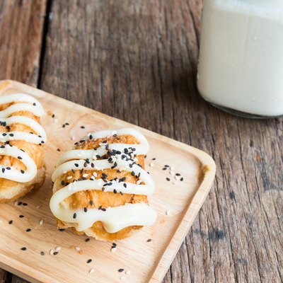 Buns with Sweetened Condensed Milk and Sesame black and white , with glass of milk on wooden background