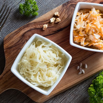 Fermented cabbage and a mix of fermented cabbage with carrots in two square bowls