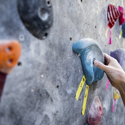 Cropped image of athlete holding rock on climbing wall